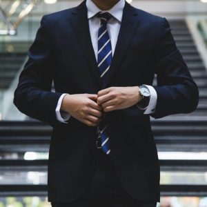 The best men's work shoes for all-day style and comfort in the office. Man in a suit at the office.