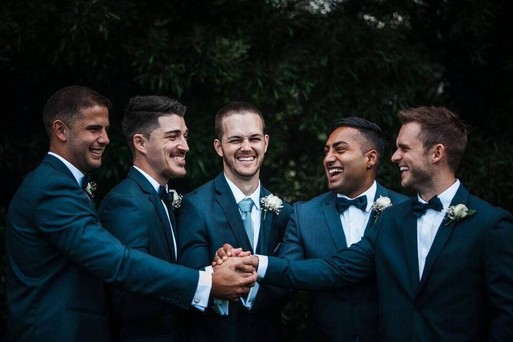 Groom and groomsmen all in matching suits.